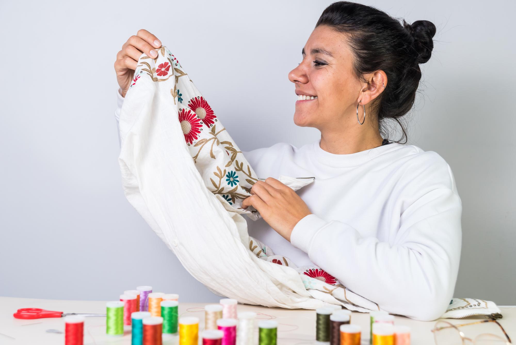 Instructor demonstrating embroidery to a student
